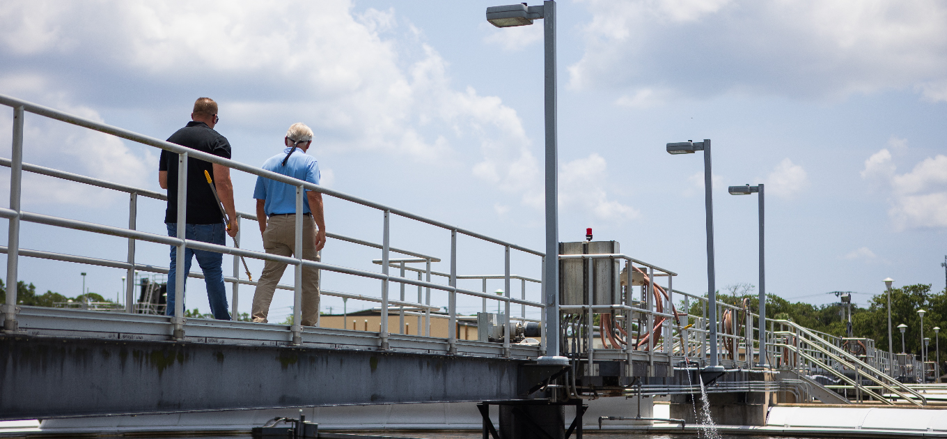 Two men walking on a water treatment tank platform